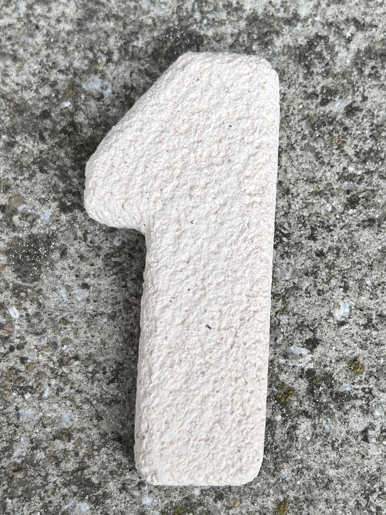 Op de afbeelding: Een set van drie keramische mokken met een gespikkelde, matte afwerking. De mokken zijn in de kleuren cr&egrave;me, lichtgrijs en donkergrijs. Elke mok heeft een eenvoudig, minimalistisch ontwerp en een afgeronde handgreep.