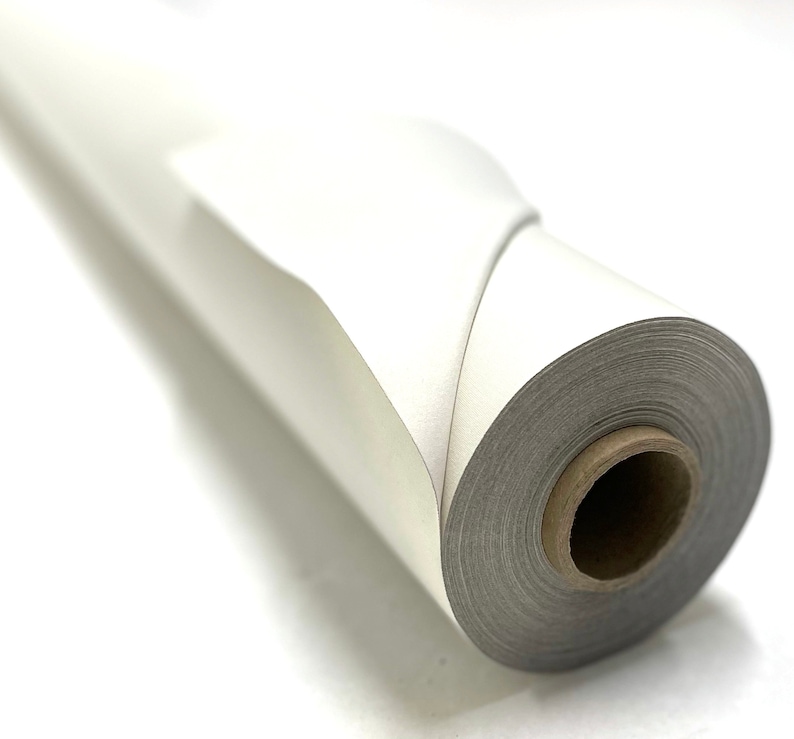 Op de afbeelding: Een rol wit papier is strak opgerold, met het uiteinde van de rol omgeslagen. Het papier is glad en heeft een lichte glans.