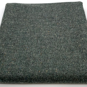 May include: A dark green fabric with a speckled texture. The fabric is folded in half and appears to be a piece of upholstery or drapery.