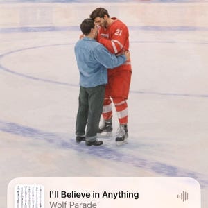 May include: A digital wallpaper showing two men embracing on an ice rink. One wears a red hockey jersey with the number 21. The time 16:55 is displayed. The music player shows "I'll Believe in Anything" by Wolf Parade.