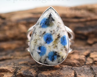 May include: A silver ring with a teardrop-shaped blue and white kyanite gemstone. The gemstone has a speckled pattern of blue and white.