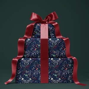 K&ouml;nnte beinhalten: Drei gestapelte Geschenkboxen, verpackt in marineblauem Papier mit floralem Muster. Die Boxen sind mit einem breiten, tiefroten Satinband und einer passenden Schleife verziert. Der Hintergrund ist dunkelgr&uuml;n.