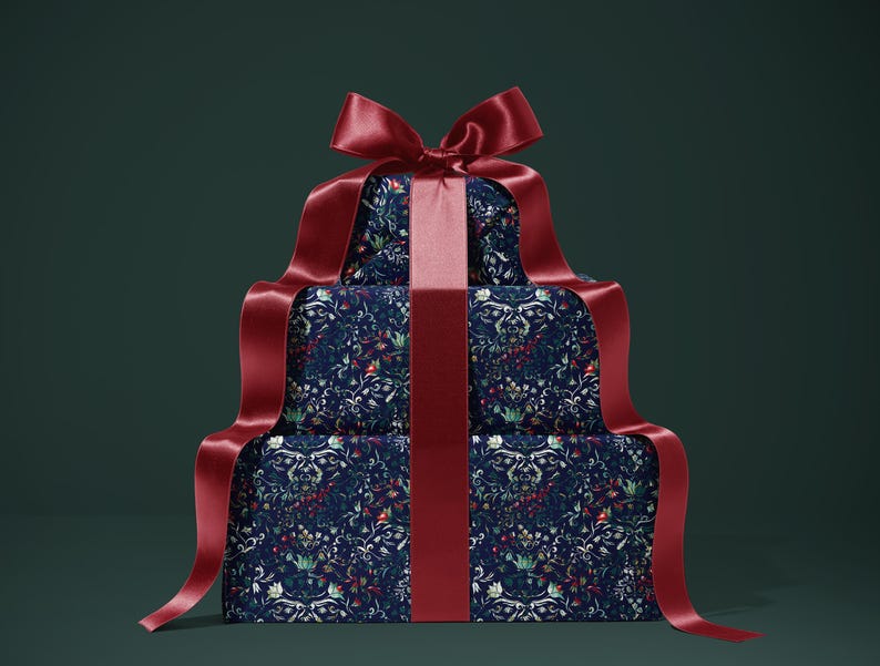 K&ouml;nnte beinhalten: Drei gestapelte Geschenkboxen, verpackt in marineblauem Papier mit floralem Muster. Die Boxen sind mit einem breiten, tiefroten Satinband und einer passenden Schleife verziert. Der Hintergrund ist dunkelgr&uuml;n.