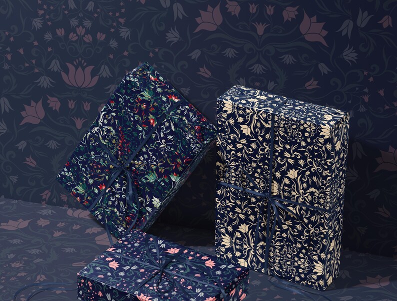 K&ouml;nnte beinhalten: Drei Geschenkboxen, verpackt in Papier mit floralen Mustern. Die Boxen sind mit dunkelblauen B&auml;ndern gebunden. Der Hintergrund ist ein dunkelblaues Blumenmuster.
