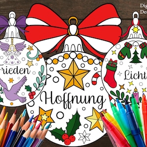 May include: Three white Christmas ornament designs with the words "Frieden", "Hoffnung", and "Licht". Each ornament features festive illustrations and is surrounded by colored pencils and markers. A large red bow is at the top.