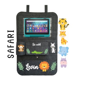 May include: Gray felt car seat organizer with a tablet holder, two pockets, and a zippered pocket. The organizer has a green leaf design and features a variety of animal illustrations, including a monkey, zebra, crocodile, lion, giraffe, elephant, and hippopotamus. The text "See wild" and "Levin" is printed on the organizer.