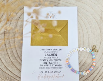 KIGAKIND-Armband aus Katsukiperlen und Regenbogenanhänger in einem Minibriefumschlag auf einem Kärtchen mit Kindergartentext |personalisiert