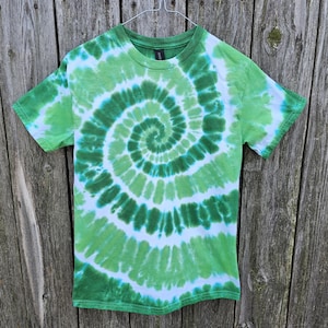 Könnte beinhalten: Ein grün-weißes Batik-T-Shirt mit einem Spiralmuster.