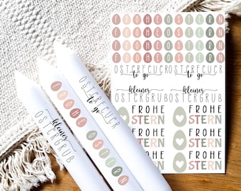 May include: Three white tubes with the text "Frohe Ostern" and "kleiner Ostergrubb" printed on them. The tubes are surrounded by a sheet of stickers with the text "Frohe Ostern" and "kleiner Ostergrubb" printed on them.