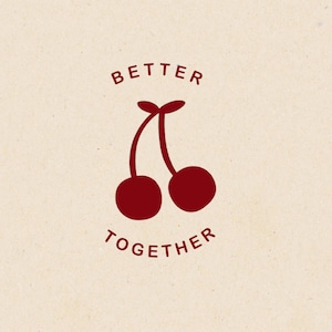 Può includere: Due ciliegie rosse con steli, una accanto all'altra, con il testo "Better Together" sopra e sotto le ciliegie.