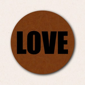 May include: A brown leather coaster with the word "LOVE" printed in black.