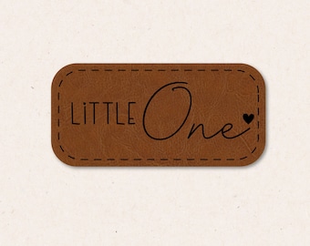 May include: A brown leather patch with the text "LITTLE One" and a small heart.