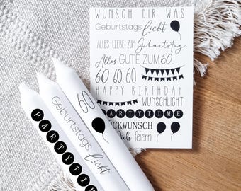 May include: White birthday candles with black text and a greeting card. The candles have the words "Party Time" and "Geburtstags Licht" printed on them. The card says "Happy Birthday" and "Alles Gute zum 60."