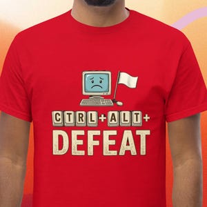 Puede incluir: Camiseta roja con un diseño desgastado. El texto "CTRL+ALT+DEFEAT" presenta un monitor de ordenador con una cara triste, un teclado, un ratón y una bandera blanca. Un diseño humorístico para los entusiastas de la informática.