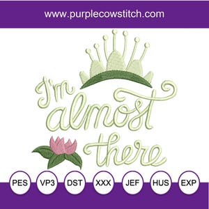 Puede incluir: Diseño bordado con el texto "I'm almost there" en fuente cursiva, coronado con una corona verde y una flor de loto rosa. Incluye varios formatos de archivo de bordado.