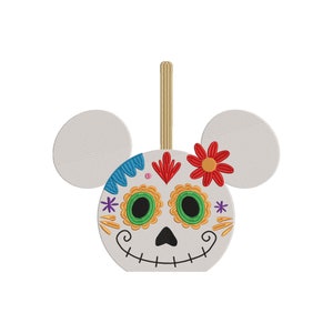 May include: White Mickey Mouse head ornament with a Day of the Dead sugar skull face. The skull is decorated with colorful flowers, swirls, and dots.