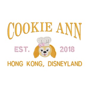 May include: A yellow and pink embroidered design with the text "COOKIE ANN EST. 2018 HONG KONG, DISNEYLAND". The design features a cartoon dog wearing a chef's hat.