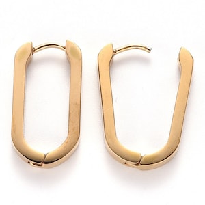 Op de afbeelding: Een paar gouden creolen met een uniek U-vormig ontwerp. De oorbellen zijn gemaakt van metaal en hebben een gepolijste afwerking.