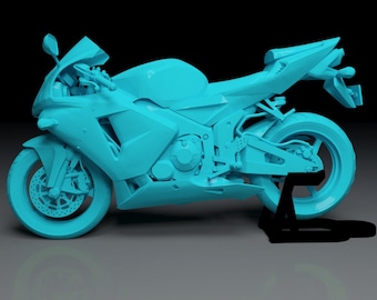 May include: A blue and white motorcycle model on a black stand. The motorcycle has a sleek design with a pointed nose and a single seat.
