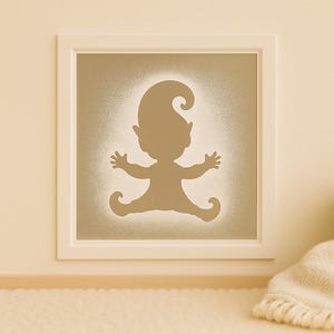 Puede incluir: Una obra de arte enmarcada que presenta la silueta de un elfo caprichoso con los brazos extendidos y los pies rizados. El elfo es de color marrón claro, sobre un fondo texturizado blanquecino. El marco es blanco y está montado en una pared beige.