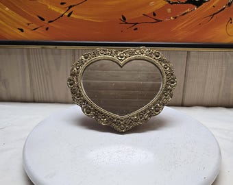 Espejo antiguo de latón con forma de corazón y relieve de rosa estilo Regencia.