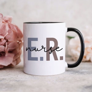 Pode incluir: Caneca de cer&acirc;mica branca com borda e al&ccedil;a pretas. A caneca tem o texto "E.R. nurse" impresso em preto, cinza e marrom.