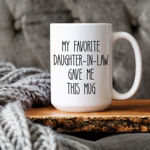 May include: White ceramic mug with black text that reads "My favourite daughter-in-law gave me this mug".