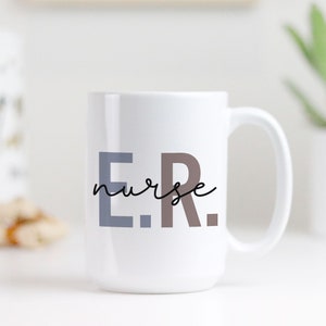 Pode incluir: Caneca de cer&acirc;mica branca com o texto "E.R. nurse" em letras pretas, cinzas e marrons.