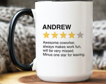 May include: White ceramic mug with a black handle and rim. The mug features the name "ANDREW" in black text, along with a rating of four gold stars and one gray star. Text below reads: "Awesome coworker, always makes work fun, will be very missed. Minus one star for leaving."