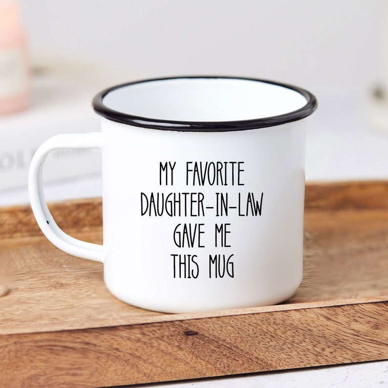May include: White enamel mug with a black rim and black text that reads "My favourite daughter-in-law gave me this mug".