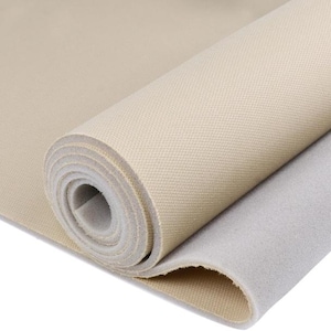 Könnte beinhalten: Ein beigefarbener Stoff mit einer Schaumstoffunterseite. Der Stoff ist aufgerollt und der Schaumstoff ist sichtbar.