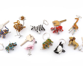 May include: A collection of beaded animal keychains, including a zebra, giraffe, elephant, ostrich, hippopotamus, flamingo, rhino, and a black and white dog. The keychains are made of colorful beads and wire.
