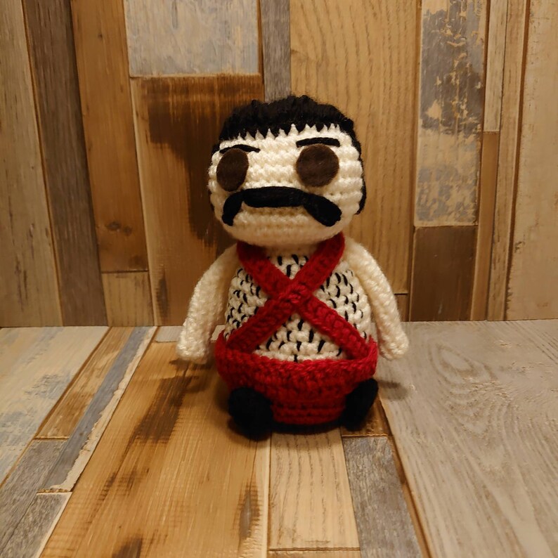 Sean Connery inspired crochet doll dressed in his iconic blue romper