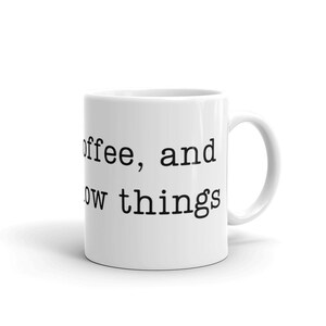 May include: White ceramic coffee mug with black text that reads "Coffee, and now things".