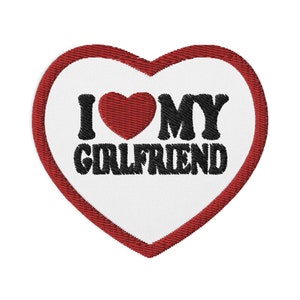May include: Red heart-shaped patch with white background and black embroidered text that reads "I love my girlfriend".