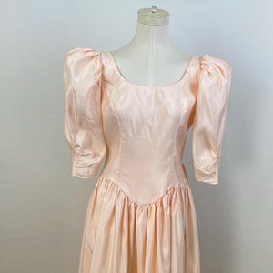 Vintage 80s Soft Peach Criss-Cross Back Sweetened With Candy Box Bow Fitted Body with Scoop Neck And Basket Waist Tea-Length Evening Dress.