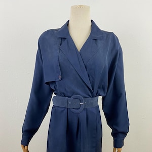 May include: A navy blue wrap dress with a long sleeve and a belt. The dress has a collar and a button closure.