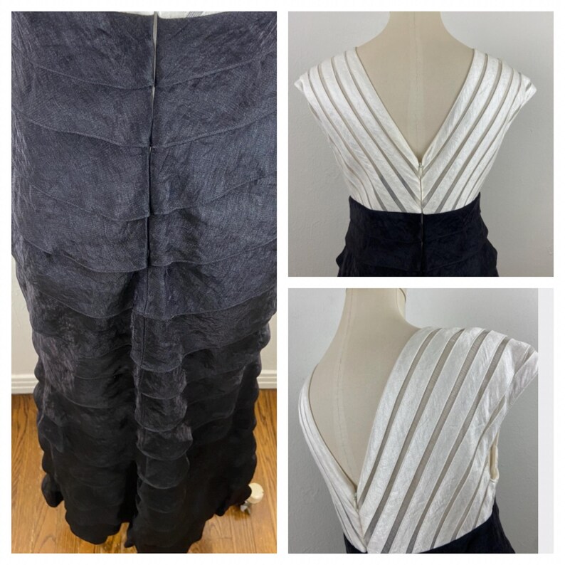 May include: A black and white formal dress with a tiered skirt and a V-neckline. The bodice is white with vertical stripes, and the skirt is black. The dress is displayed on a mannequin.