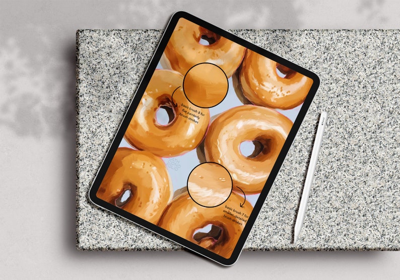 Puede incluir: Una ilustraci&oacute;n digital de donuts glaseados en la pantalla de una tableta. La imagen muestra diferentes trazos de pincel utilizados para crear la ilustraci&oacute;n. El texto en la pantalla dice "pincel b&aacute;sico 8 para una textura de donut suave y ligeramente cepillada" y "pincel b&aacute;sico 7 para trazos de pincel suaves y glaseados".