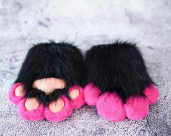 May include: A pair of black furry paw hand warmers with pink paw pads.
