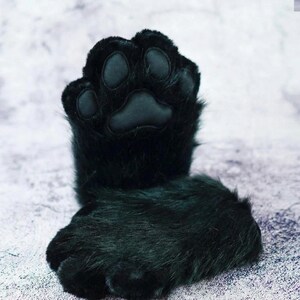 Puede incluir: Guantes de pata de piel sint&eacute;tica negra con una almohadilla acolchada y almohadillas individuales para los dedos. Los guantes est&aacute;n dise&ntilde;ados para parecerse a una pata de gato u otro animal. La piel es de color negro intenso y las almohadillas son de color negro mate.