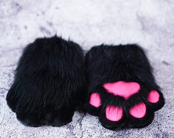 May include: A pair of black furry paw hand warmers with pink paw pads.
