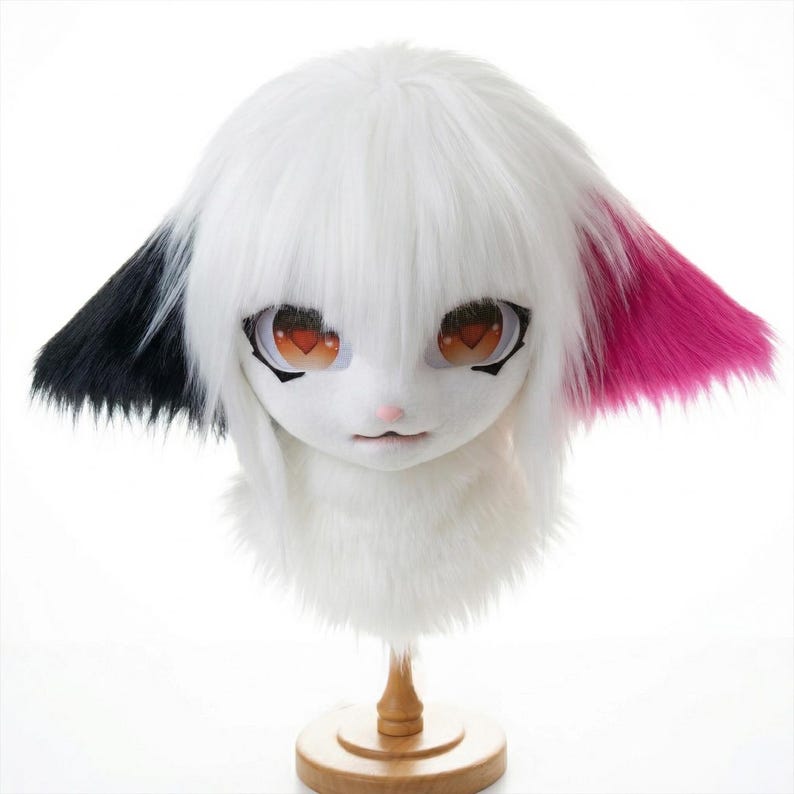 A playful white anime goat fursuit head featuring asymmetrical black and Barbie pink ears.