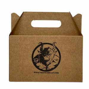 May include: A brown cardboard box with a cut-out handle. The box has a black and white logo of a monster with the text "www.thespicebeast.com" printed on the front.