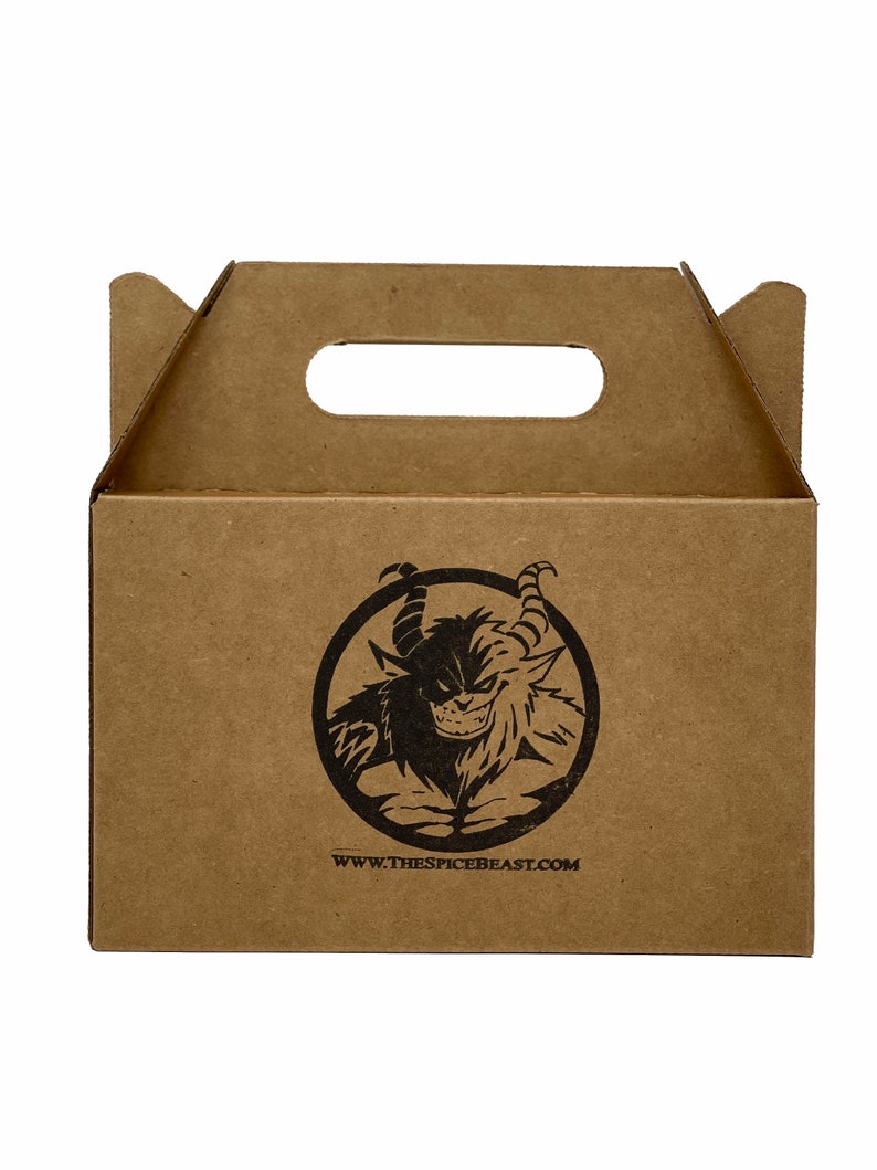 May include: A brown cardboard box with a cut-out handle. The box has a black and white logo of a monster with the text "www.thespicebeast.com" printed on the front.