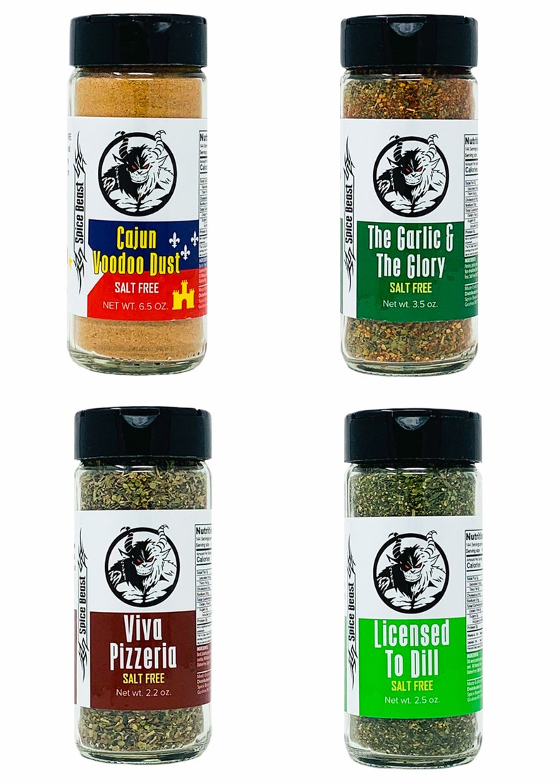 May include: Four glass spice jars with black lids and labels. Each jar contains a different blend of spices. The labels feature a cartoon devil and the names of the spice blends: Cajun Voodoo Dust, The Garlic & The Glory, Viva Pizzeria, and Licensed To Dill. All blends are salt-free.