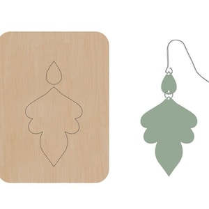 May include: A wooden template for making earrings. The template shows a teardrop-shaped earring with a decorative design.