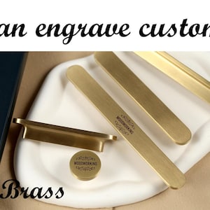 May include: Image of various hardware options. The image features cabinet pulls with leather, brass, and marble accents. The text "We can engrave customized" is displayed at the top, with the material names below each hardware type.