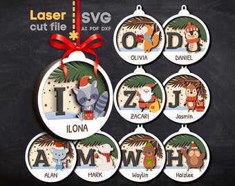 May include: Eight laser cut wooden Christmas ornaments with different letters and animal designs. Each ornament features a letter, an animal, and a name. The letters are I, O, D, Z, J, A, M, W, and H. The animals are a raccoon, a fox, a penguin, Santa Claus, a reindeer, a mouse, a polar bear, a bear, and an owl. The names are Ilona, Olivia, Daniel, Zacari, Jasmin, Alan, Mark, Waylin, and Haizlee.