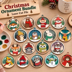 Op de afbeelding: Een set van 16 ronde houten kerstornamenten met lasergesneden dierontwerpen, waaronder een vos, beer, puppy, ijsbeer, egel, pinguïn, konijn, eland, hert, wasbeer, uil, husky, sneeuwpop en kat, allemaal voorzien van winterse accessoires.